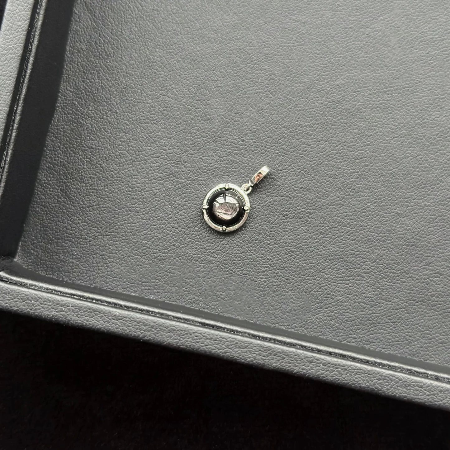 Golden Aventurine Sterling Silver Pendant on a gray leather surface