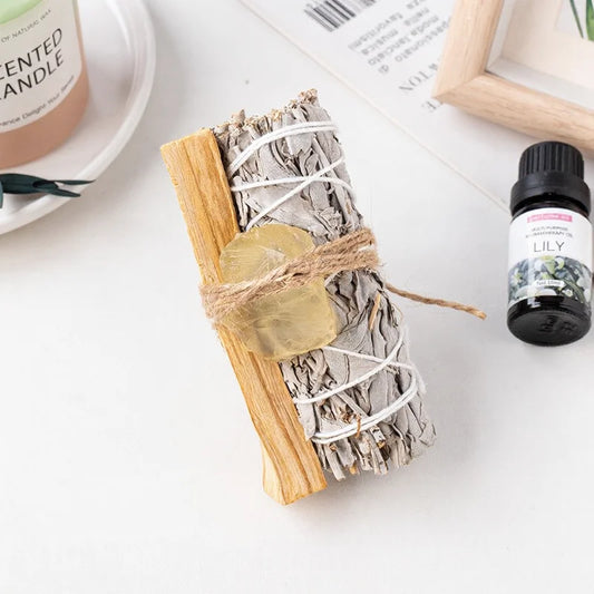 An abundance crystal kit for adults featuring a raw citrine gemstone tied to a premium white sage cleansing stick.