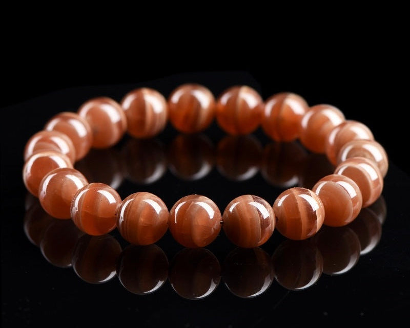 Close-up of handmade crystal bracelet with polished old mine rhodochrosite beads