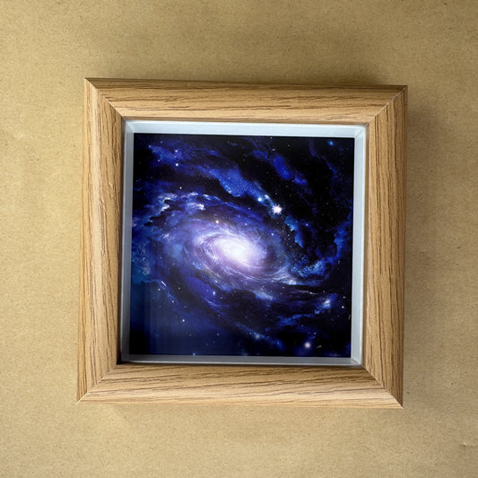 Close-up of the square deep-space nebula canvas print inside a light wood-grain frame.