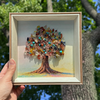 Handholding a 6-inch square Tree of Life healing crystal decor for desks.