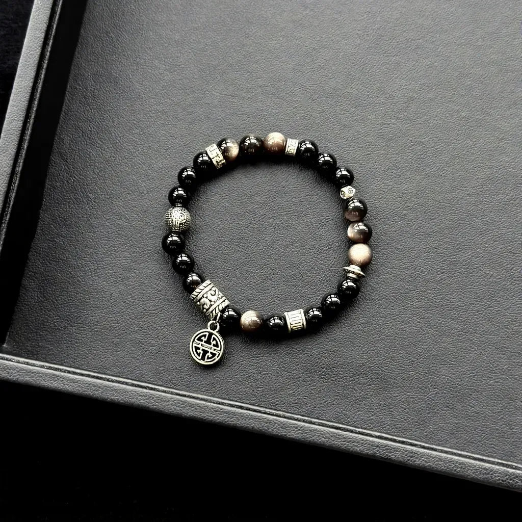 Black Agate & Silver Obsidian Bracelet on a gray surface