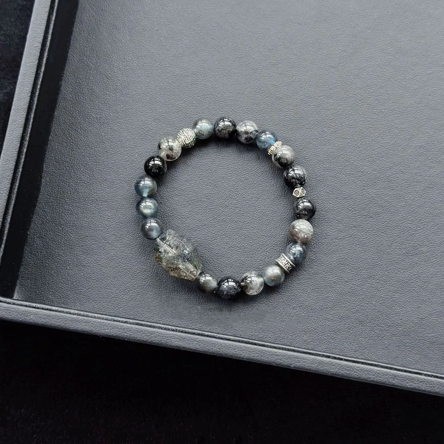 Black Rutilated Quartz & Black Flash Aquamarine & Silver Obsidian & Herkimer Diamond Bracelet on a dark surface