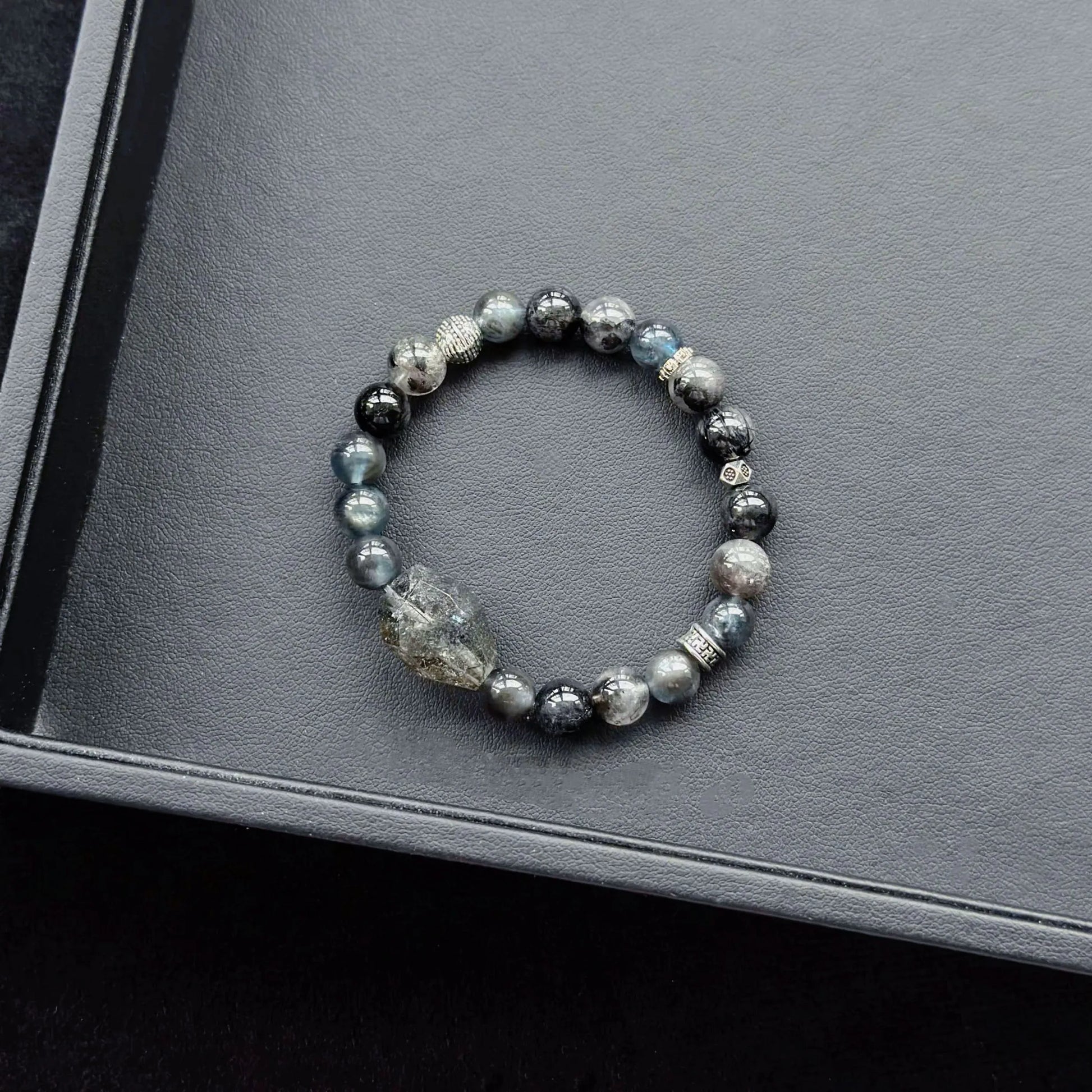 Black Rutilated Quartz & Black Flash Aquamarine & Silver Obsidian & Herkimer Diamond Bracelet on a dark surface