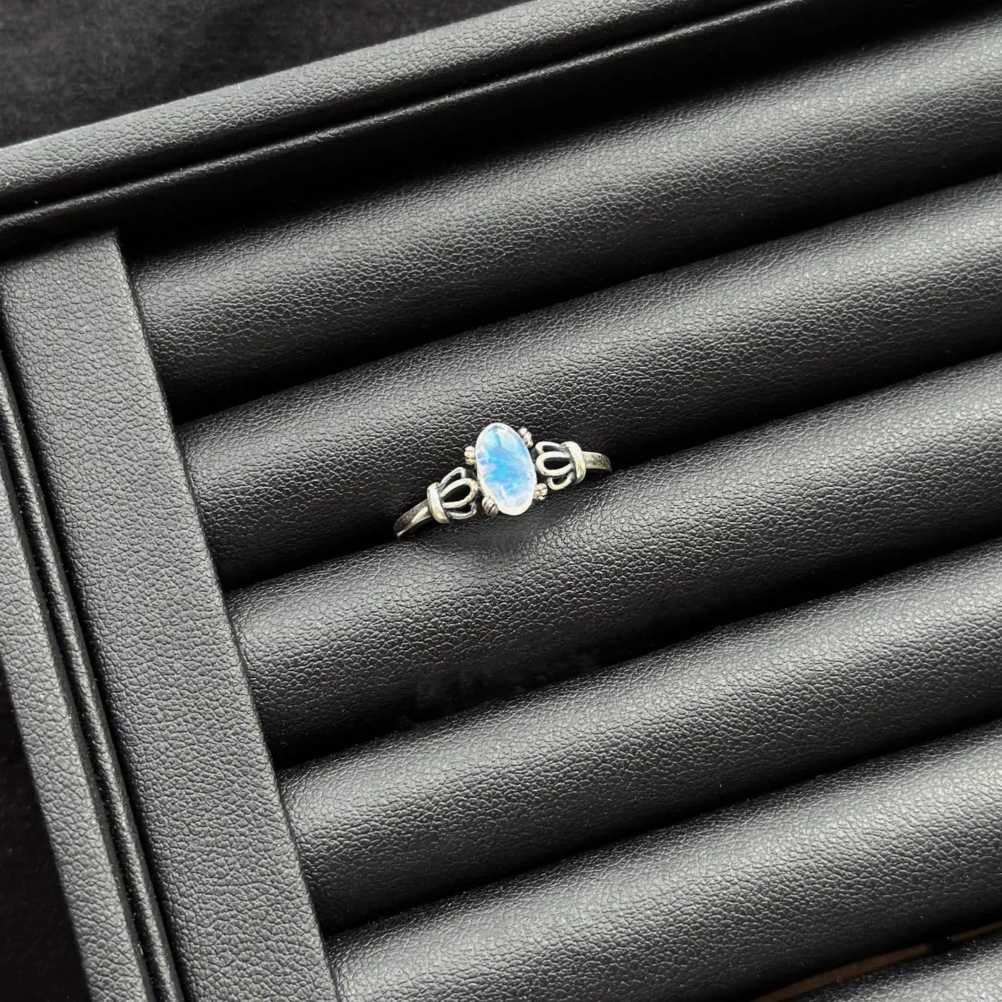 Blue Moonstone Sterling Silver Ring on a textured black surface