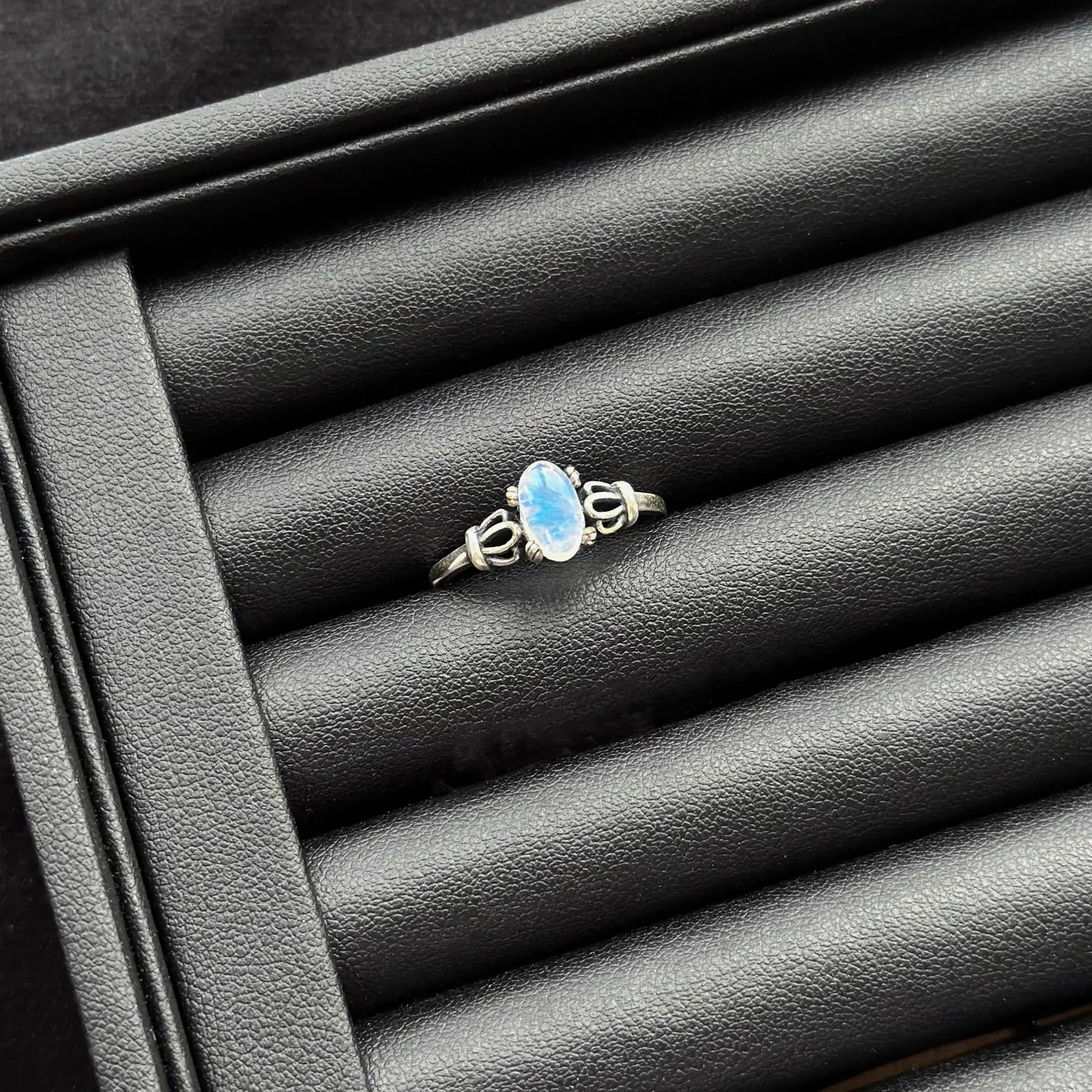 Blue Moonstone Sterling Silver Ring on a textured black surface