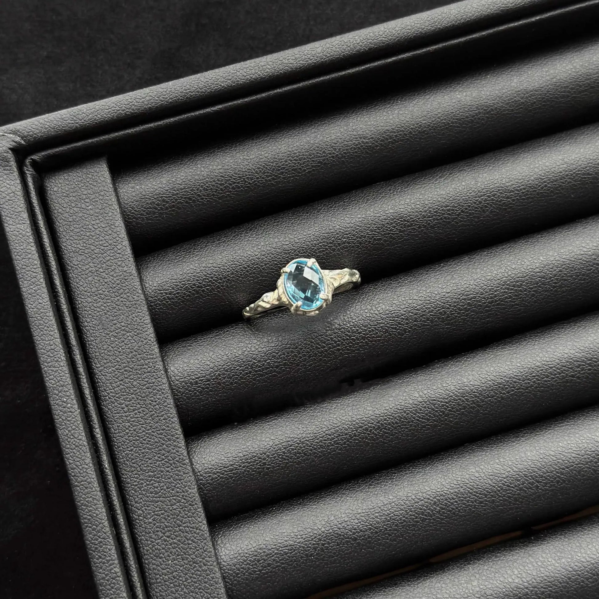 London Blue Topaz Sterling Silver Ring on a black textured surface