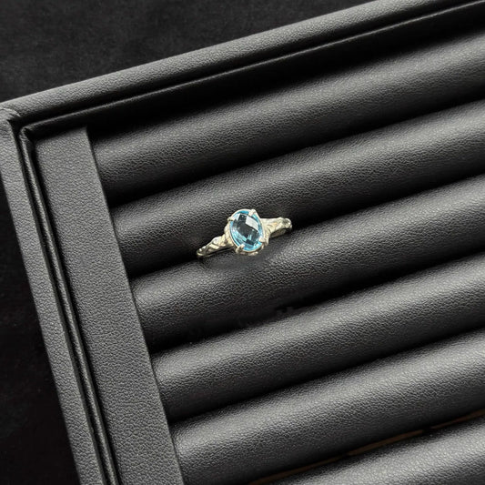 London Blue Topaz Sterling Silver Ring on a black textured surface
