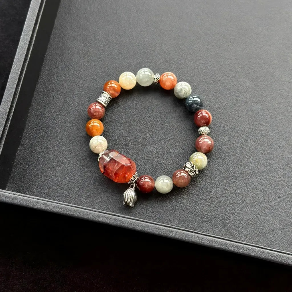Red Hematoid Quartz & Rainbow Rabbit Hair Rutilated Quartz Bracelet on a dark surface