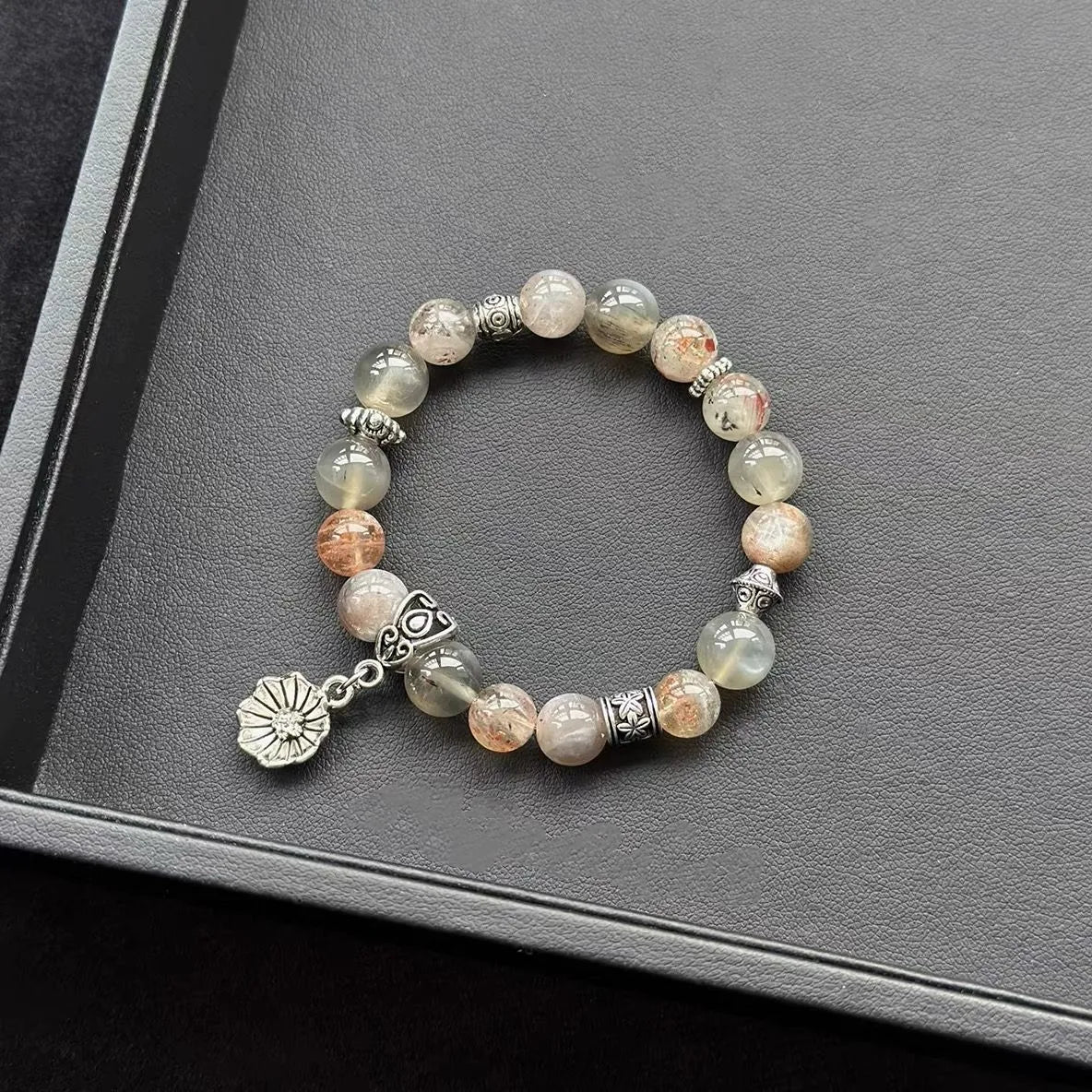 Skeletal Moonstone &  Arusha Sunstone Bracelet on a dark surface