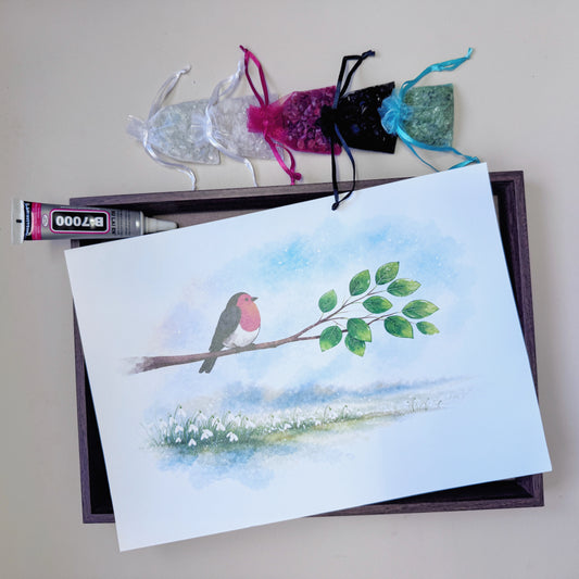 A4 size wood-grain framed Robin and Snowdrop art canvas styled with neatly arranged raw crystal chips above it for beginner mindful crafting.