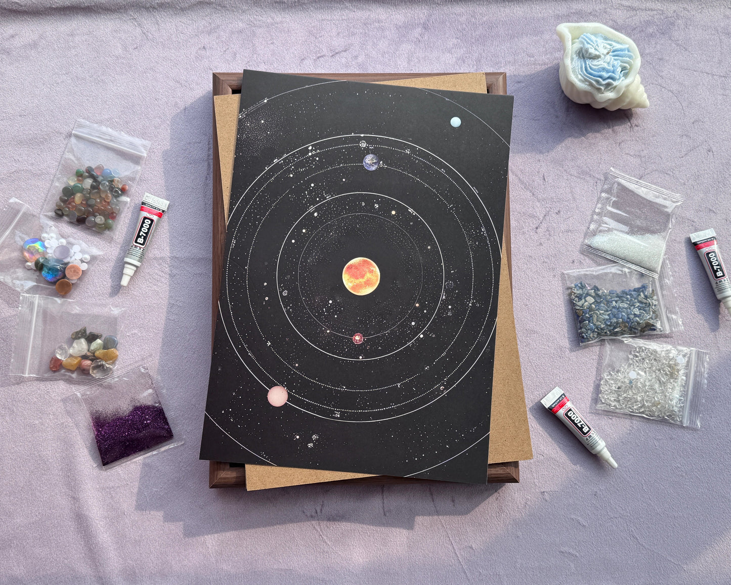 Workspace setup for the DIY Crystal Mosaic Art featuring the solar system canvas and craft supplies.