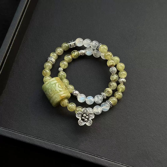 Healing crystal bracelet featuring carved Green Jade barrel, Tsavorite, and Blue Moonstone – supports love, peace, and heart chakra energy.