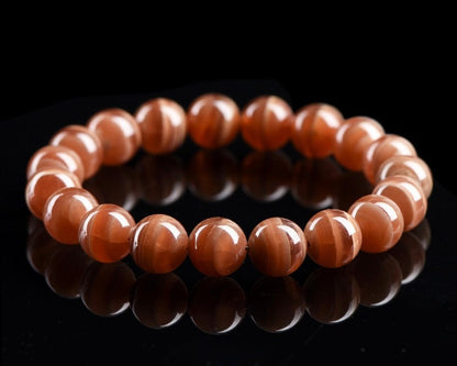 Close-up of handmade crystal bracelet with polished old mine rhodochrosite beads