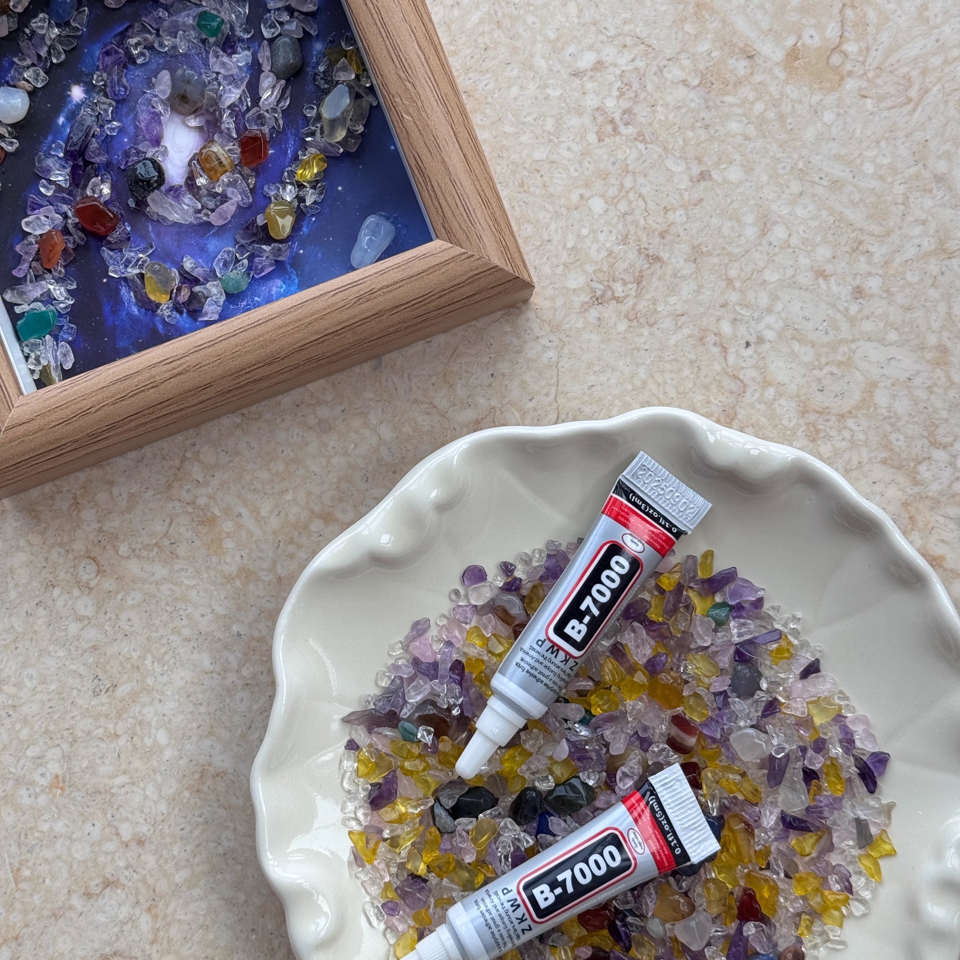 Hands-on view of applying B-7000 glue to a crystal galaxy canvas for a creative calm activity.