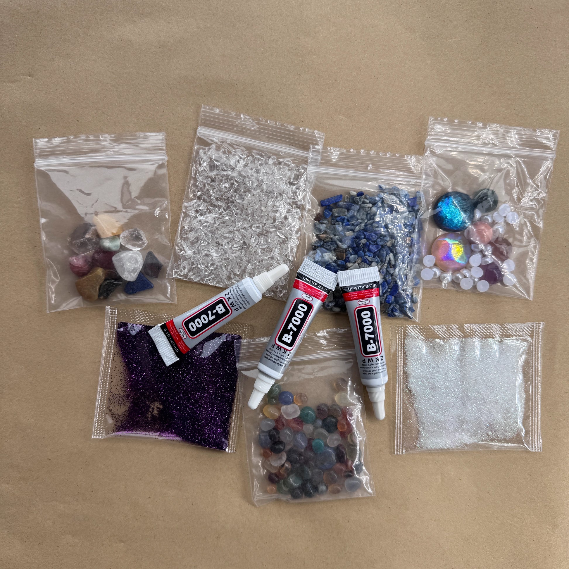 Assorted bags of Lapis Lazuli, clear quartz chips, and B-7000 glue for crystal crafting.
