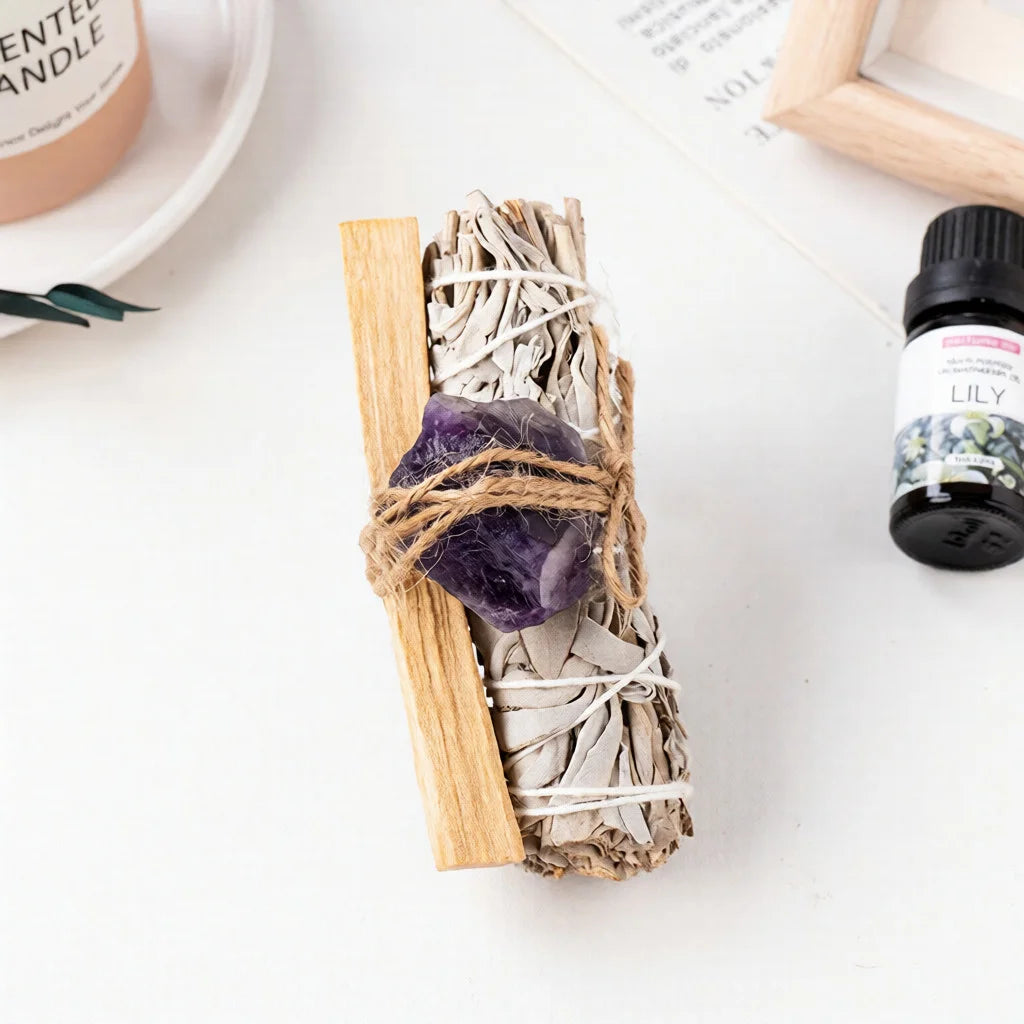 A raw purple amethyst healing crystal bound to a white sage smudge stick for anxiety relief and spiritual room aesthetics.