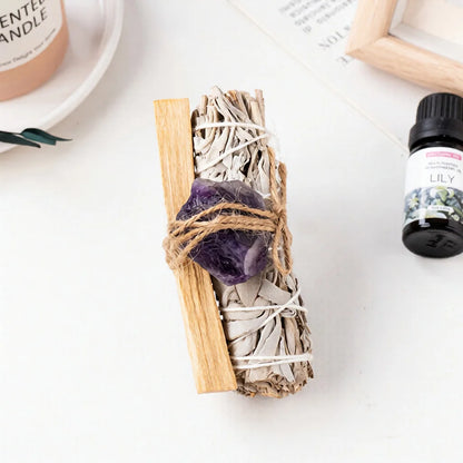A raw purple amethyst healing crystal bound to a white sage smudge stick for anxiety relief and spiritual room aesthetics.