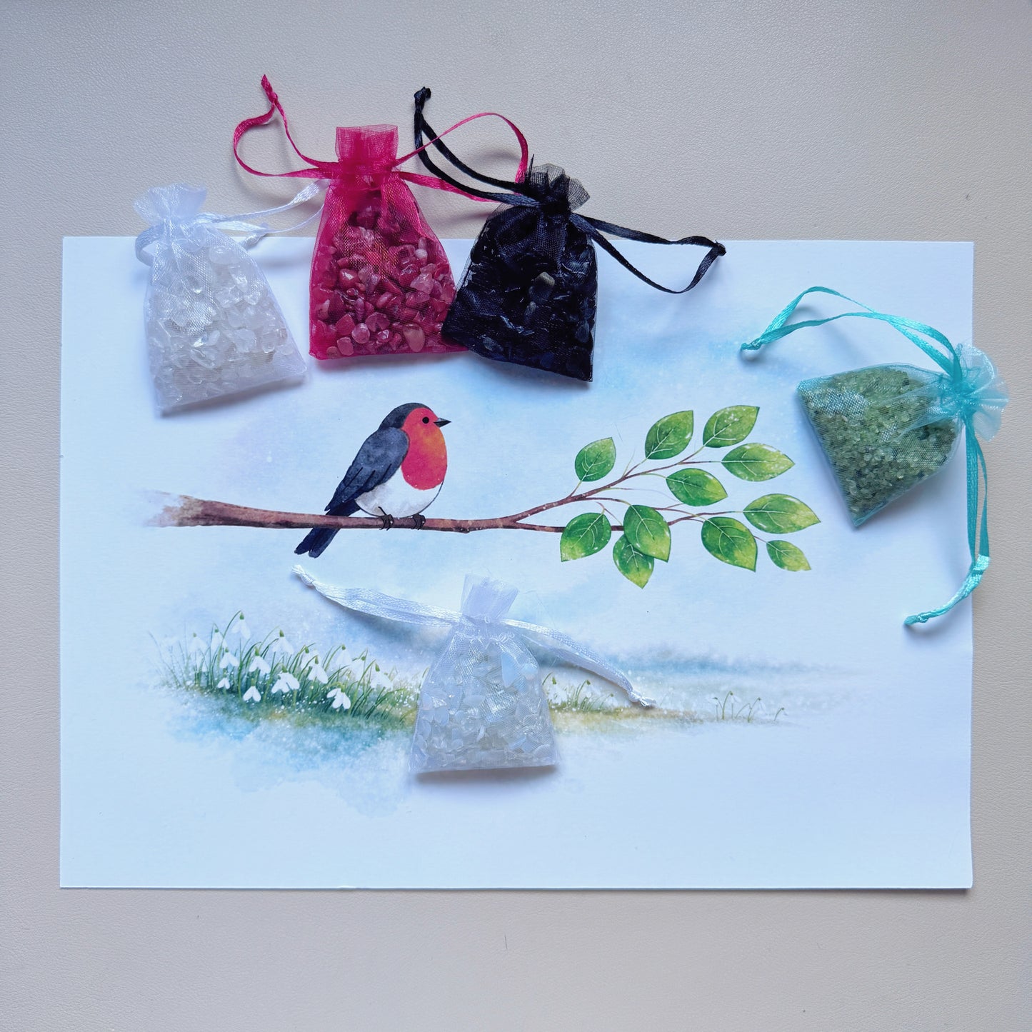 Unframed Robin and Snowdrop art canvas paired with colorful raw gemstone chips ready for natural crystal diamond painting alternative crafting.