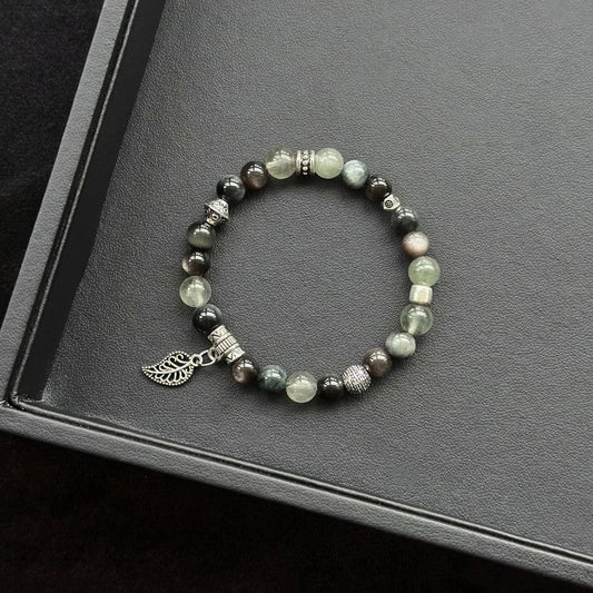 Healing crystal bracelet featuring Silver Obsidian, Hawk’s Eye, and Green Rutilated Quartz – supports grounding, protection, and mental clarity.