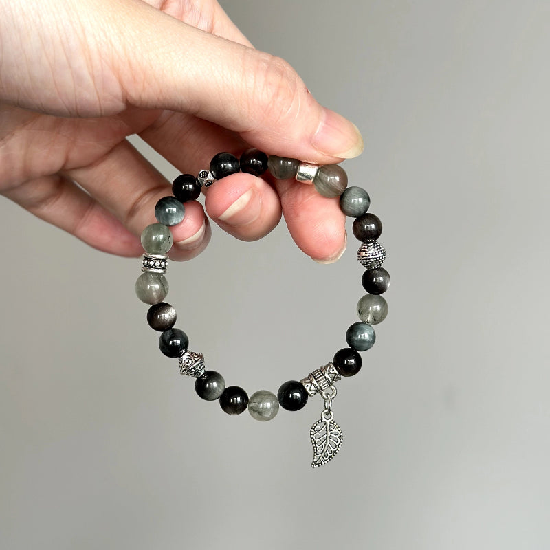 Beaded bracelet made with Silver Obsidian, Hawk’s Eye, and Green Rutilated Quartz – ideal for protection, vision, and energy balance.