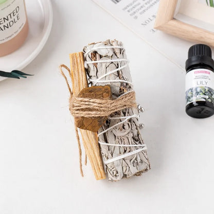 A raw tiger's eye grounding stone tied to a white sage stick, ideal as desk healing crystals and spiritual gifts.