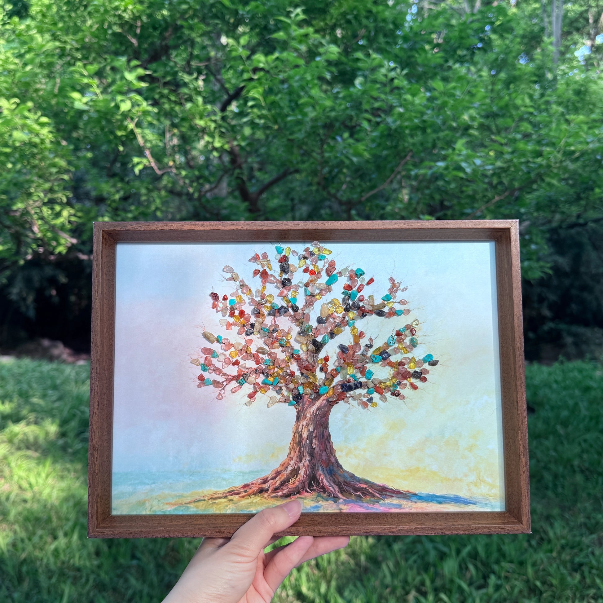 Handheld view of A4 Tree of Life crystal art with colorful natural gemstones.