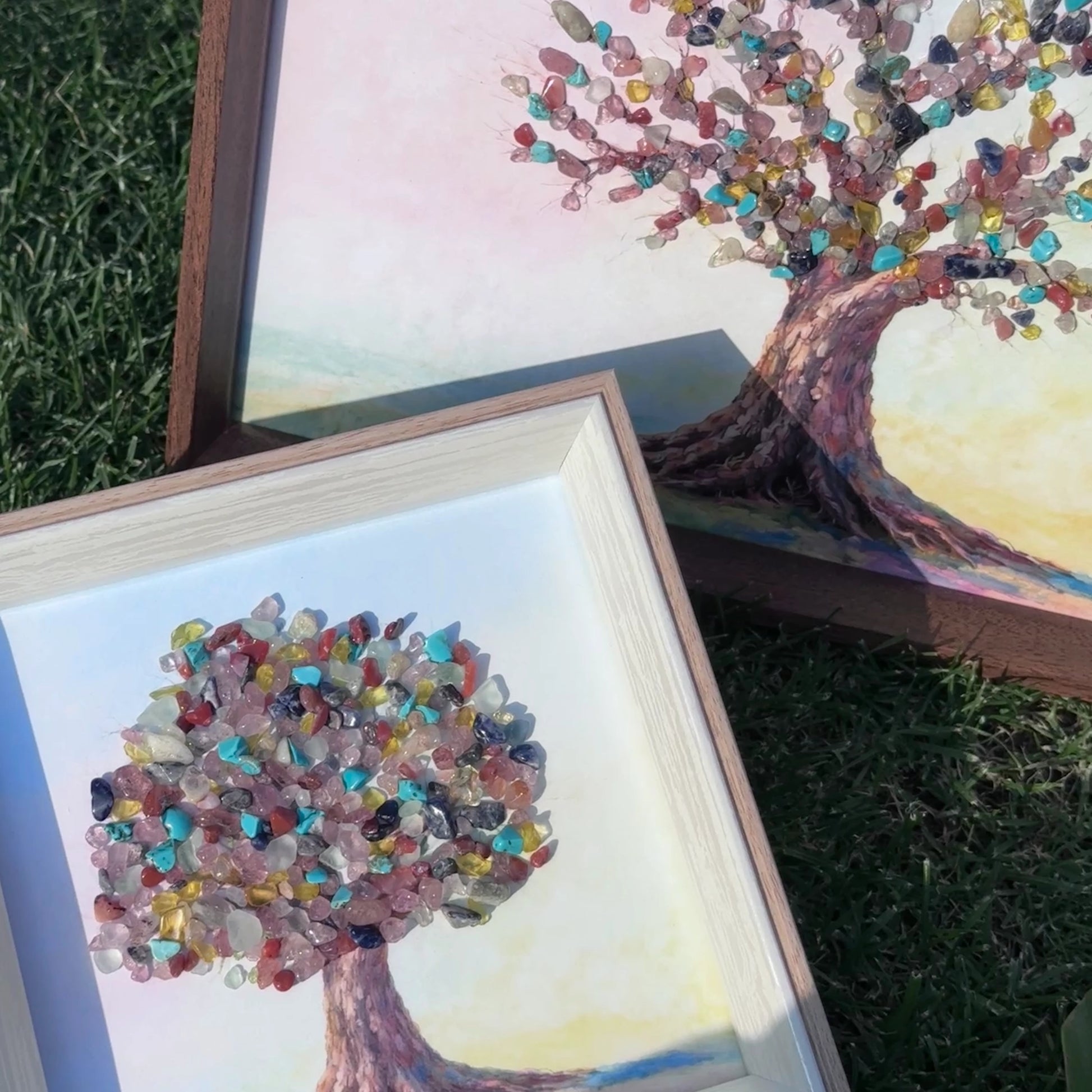 Comparison of A4 and 6-inch square Tree of Life crystal art frames on grass.